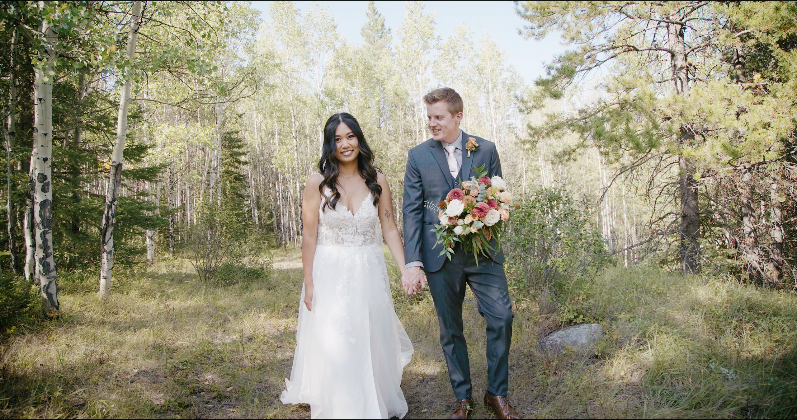 Wide cinematic frame of a bride and groom surrounded by beautiful trees & peaks during a small mountain wedding at Rundleview Parkette.